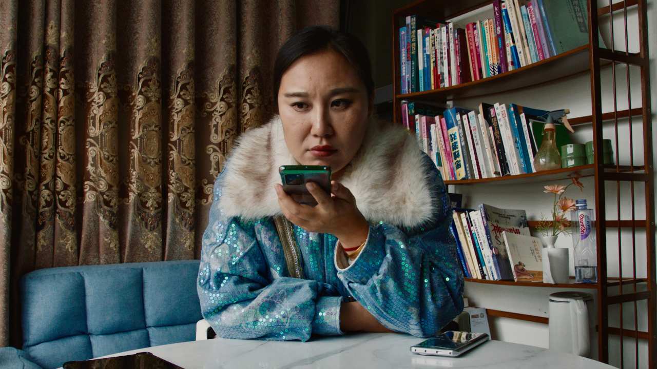 a woman with a fur trim jacket holding a phone